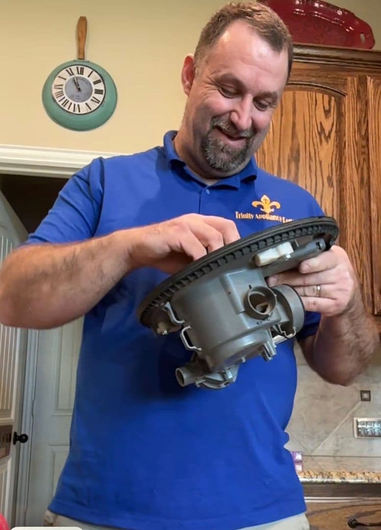 Jason Krell, owner of Trinity Appliance Repair, holding a dishwasher pump he just removed in a customer's kitchen